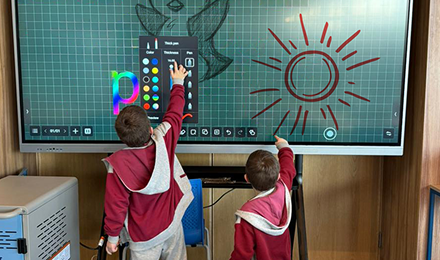 Estudiantes usando una pantalla interactiva en el aula